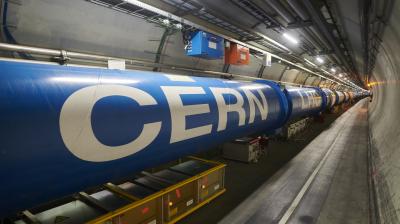 A long blue cylindrical structure in a tunnel with the word "CERN" written on it, part of the Large Hadron Collider.