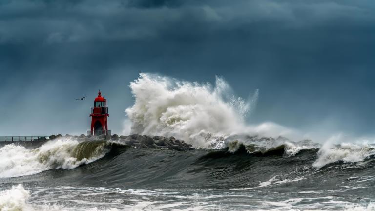 Huge wave crashing into a lighthouse
